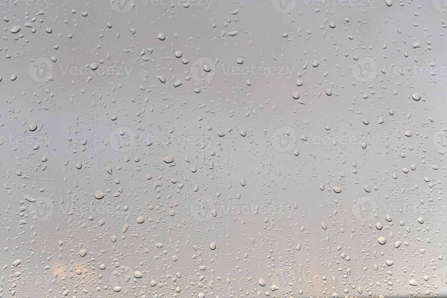 Raindrops on a window with a sunset sky in the background. photo