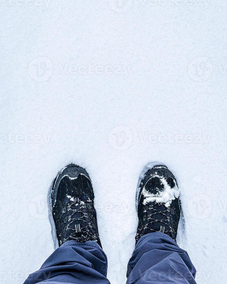 Legs in hiking boots for trekking in the snow. photo