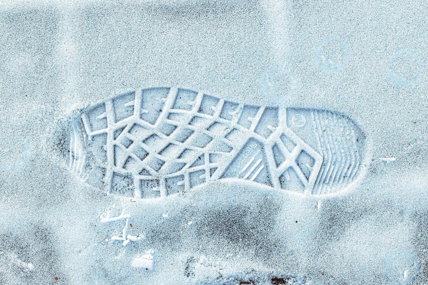 Boot track on thin first snow in winter. photo