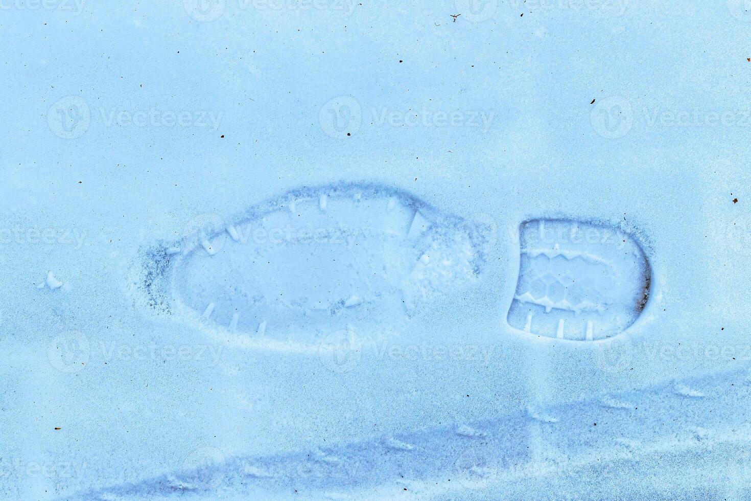 Boot track on thin first snow in winter. photo