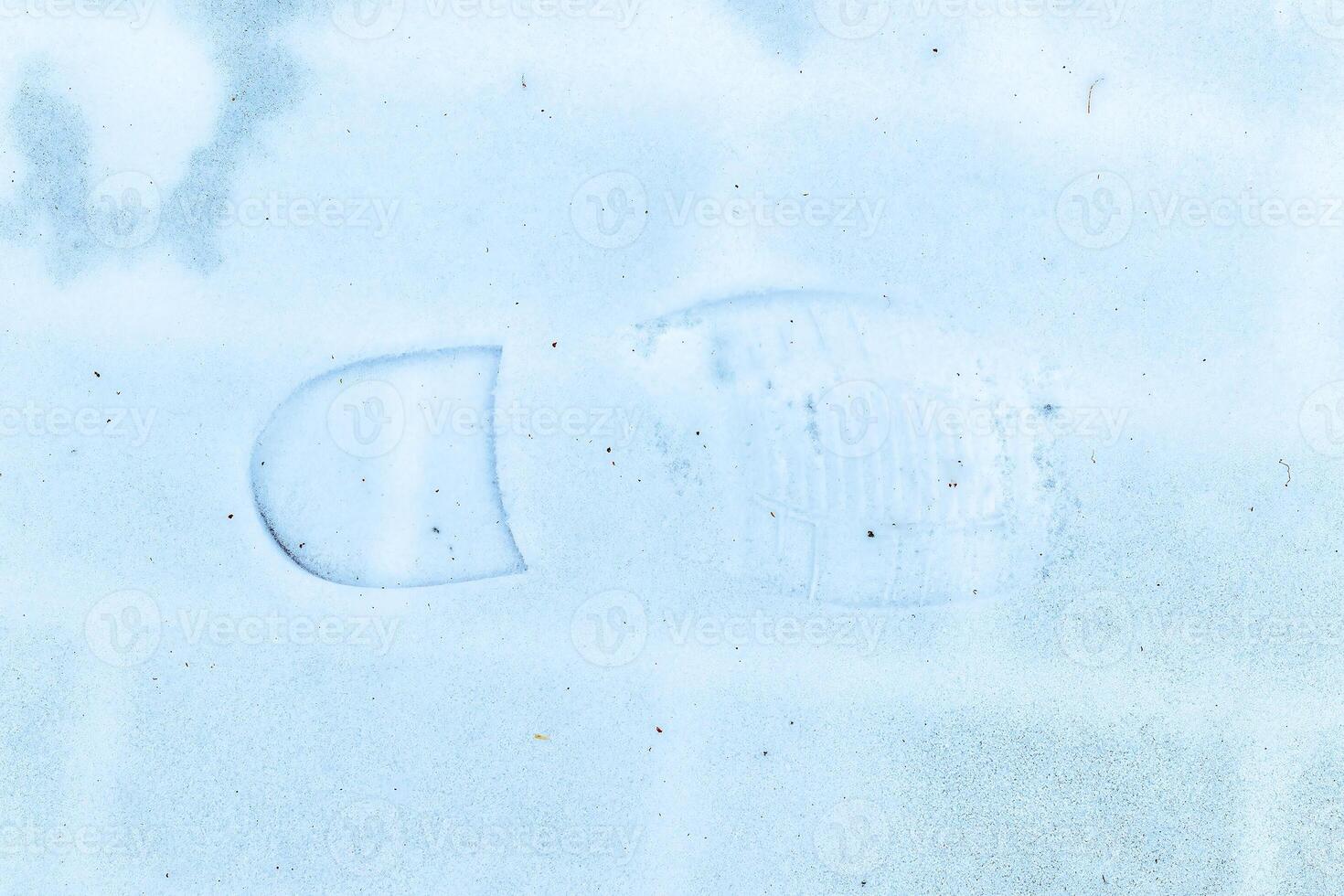 Boot track on thin first snow in winter. photo
