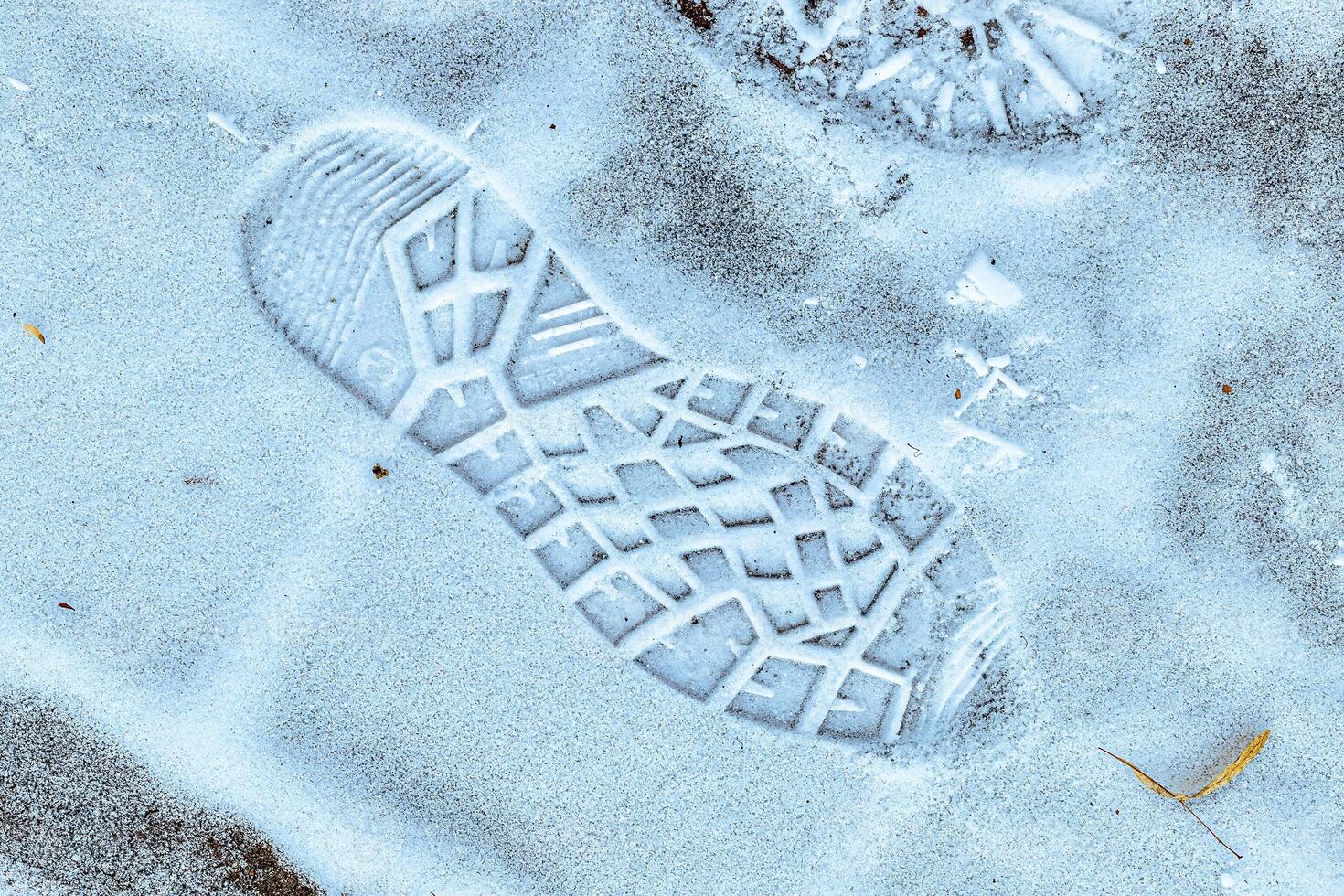 Boot track on thin first snow in winter. photo
