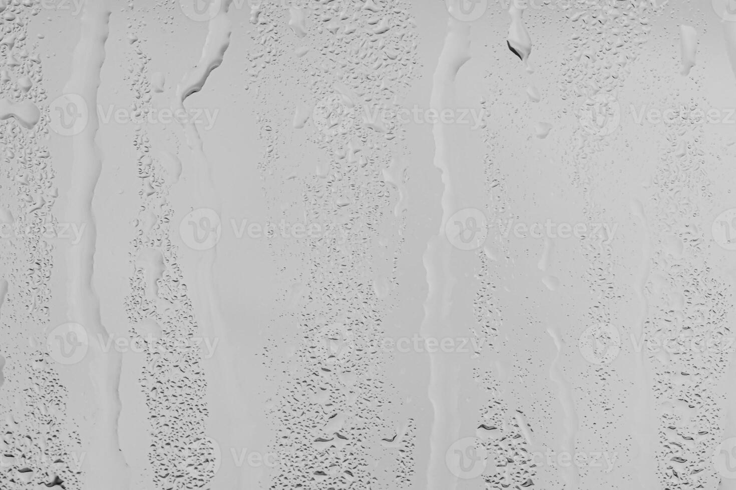 Rain drops on window glasses surface with gray sky background . Natural backdrop of raindrops. Overlay for design. The concept of bad rainy weather. photo