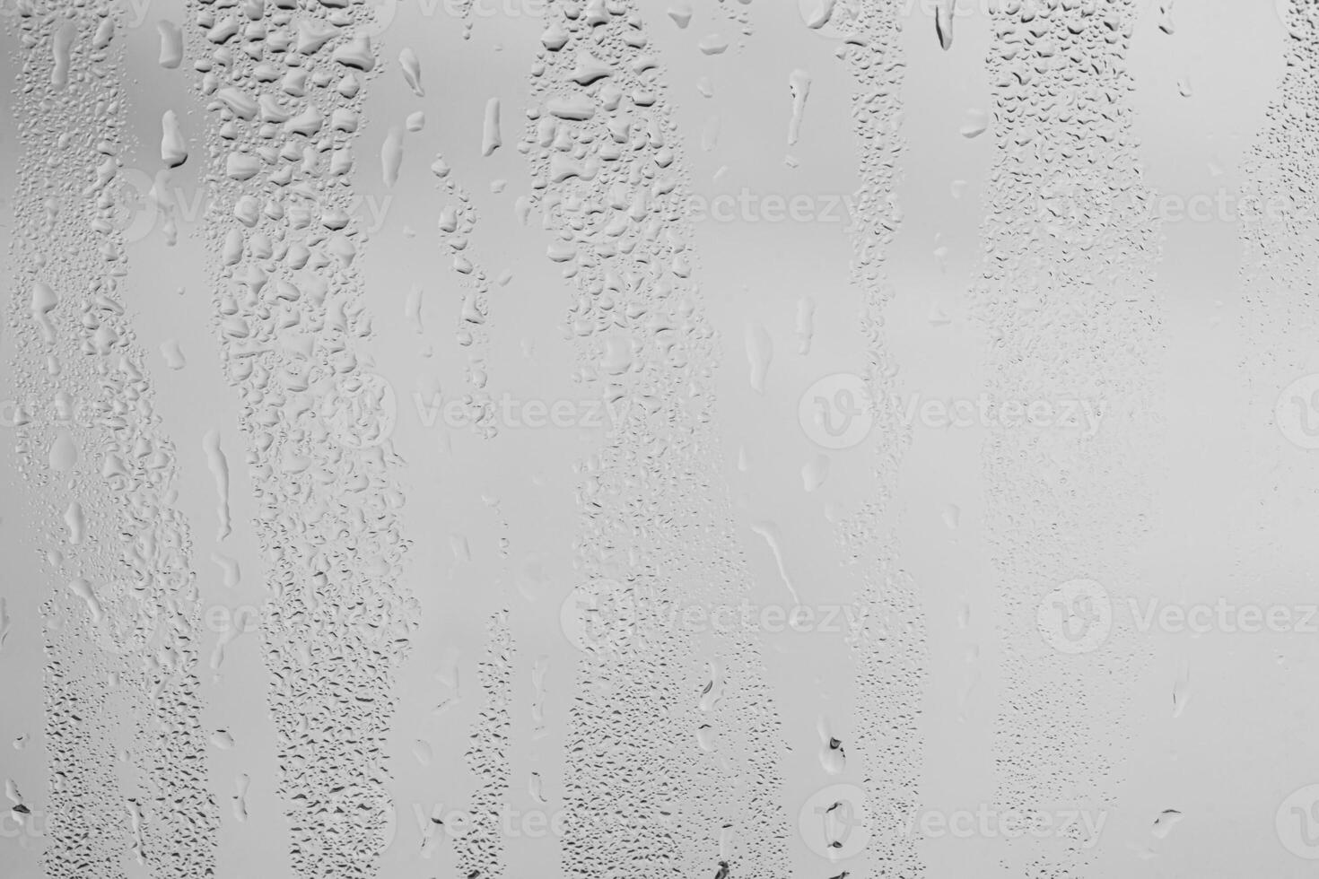 Rain drops on window glasses surface with gray sky background . Natural backdrop of raindrops. Overlay for design. The concept of bad rainy weather. photo
