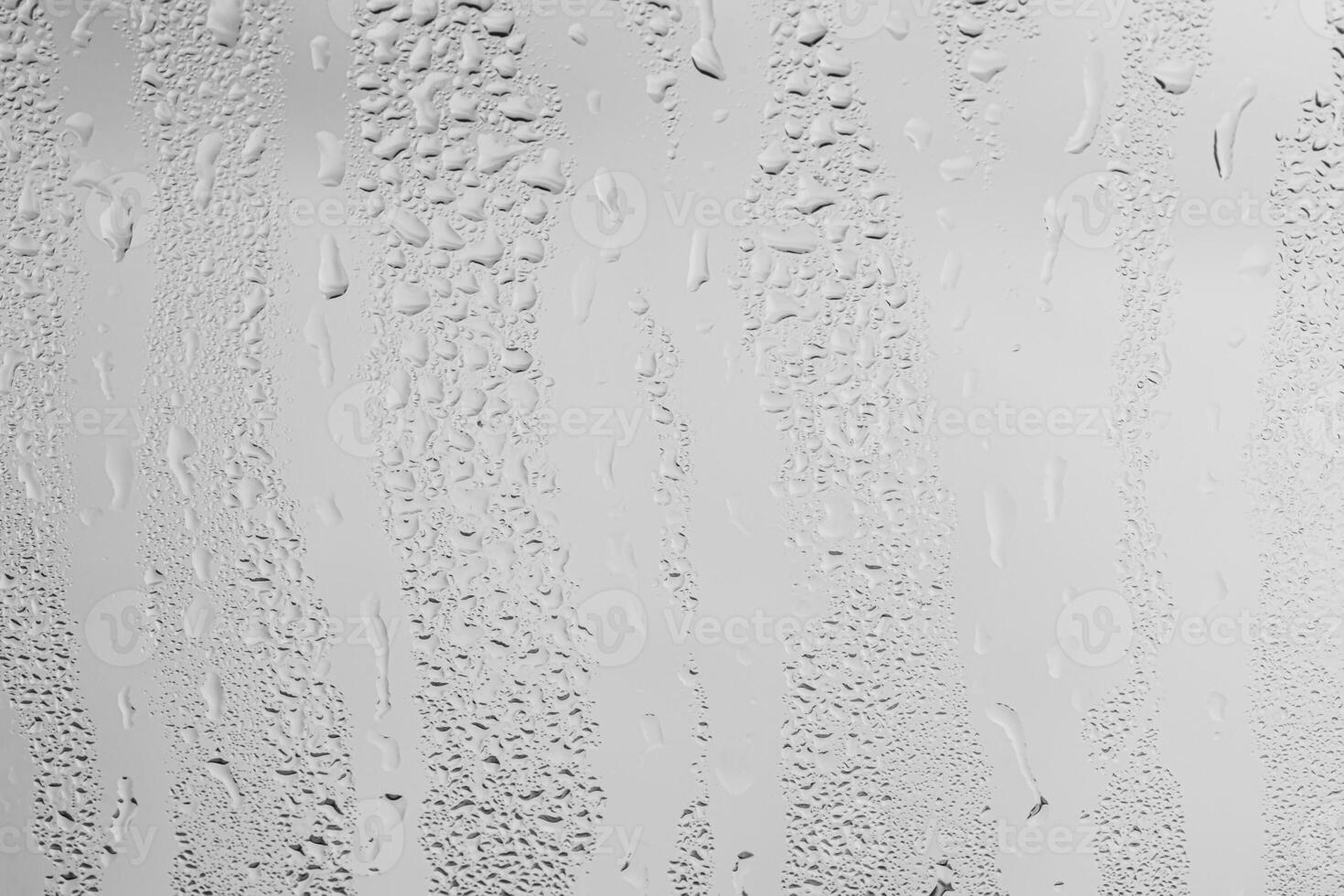 Rain drops on window glasses surface with gray sky background . Natural backdrop of raindrops. Overlay for design. The concept of bad rainy weather. photo