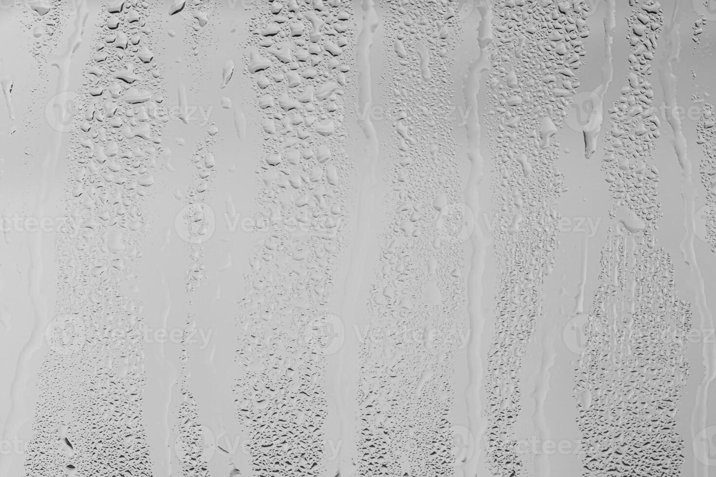 Rain drops on window glasses surface with gray sky background . Natural backdrop of raindrops. Overlay for design. The concept of bad rainy weather. photo