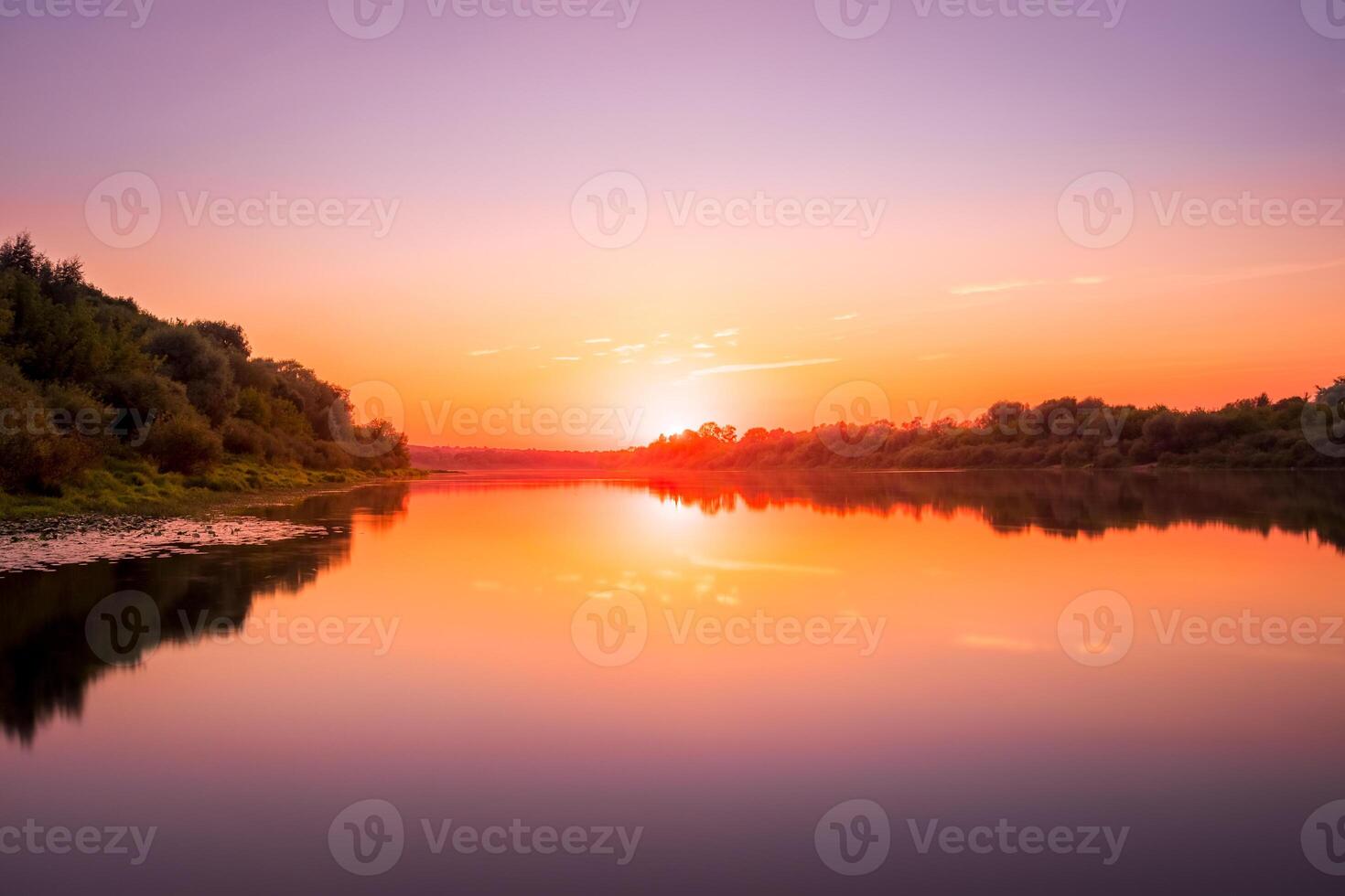 Sunset or dawn on a river with a cloudy sky and sun rays reflected in the water, water lilies and trees growing along the shore. photo