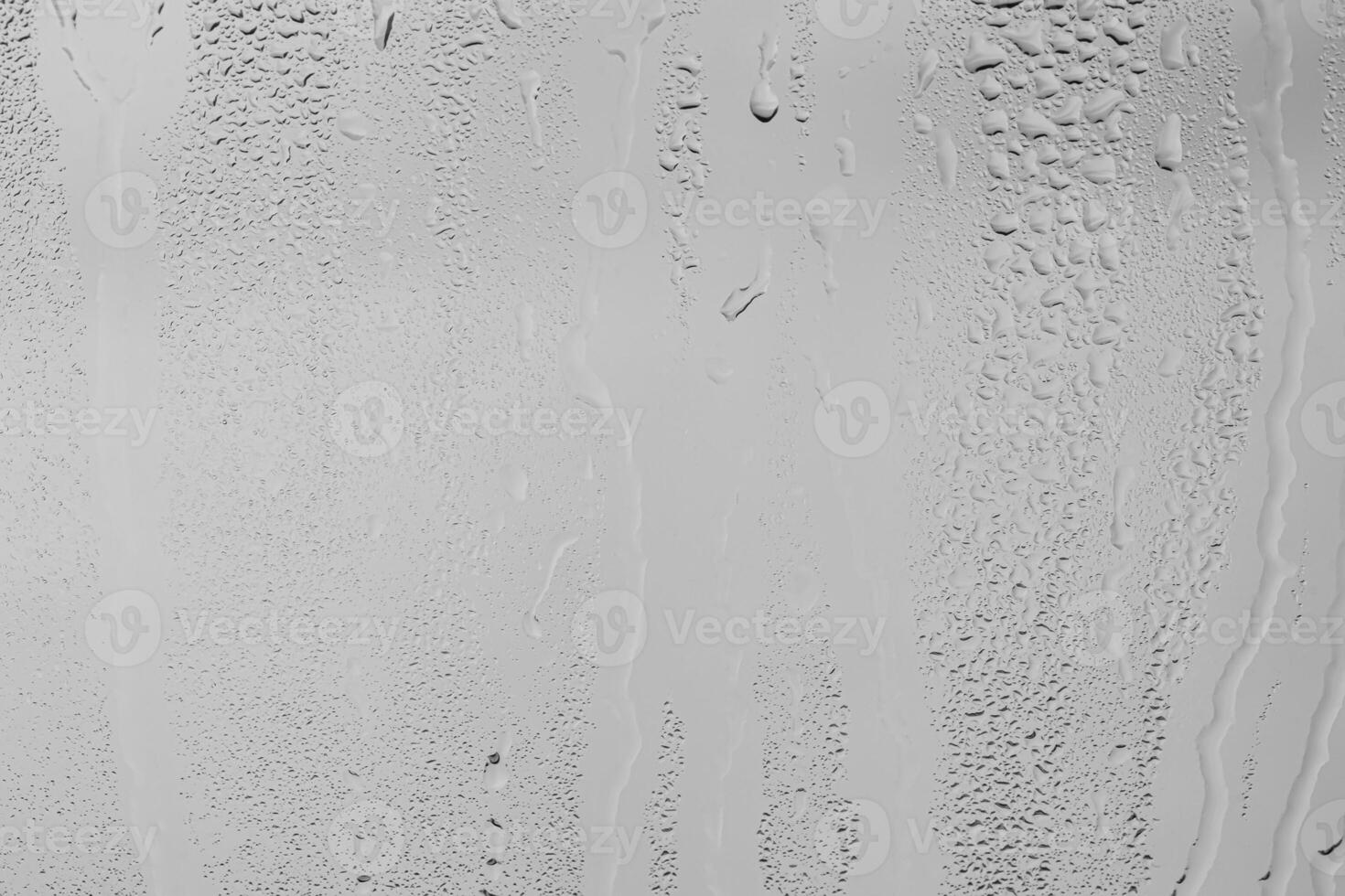 Rain drops on window glasses surface with gray sky background . Natural backdrop of raindrops. Overlay for design. The concept of bad rainy weather. photo