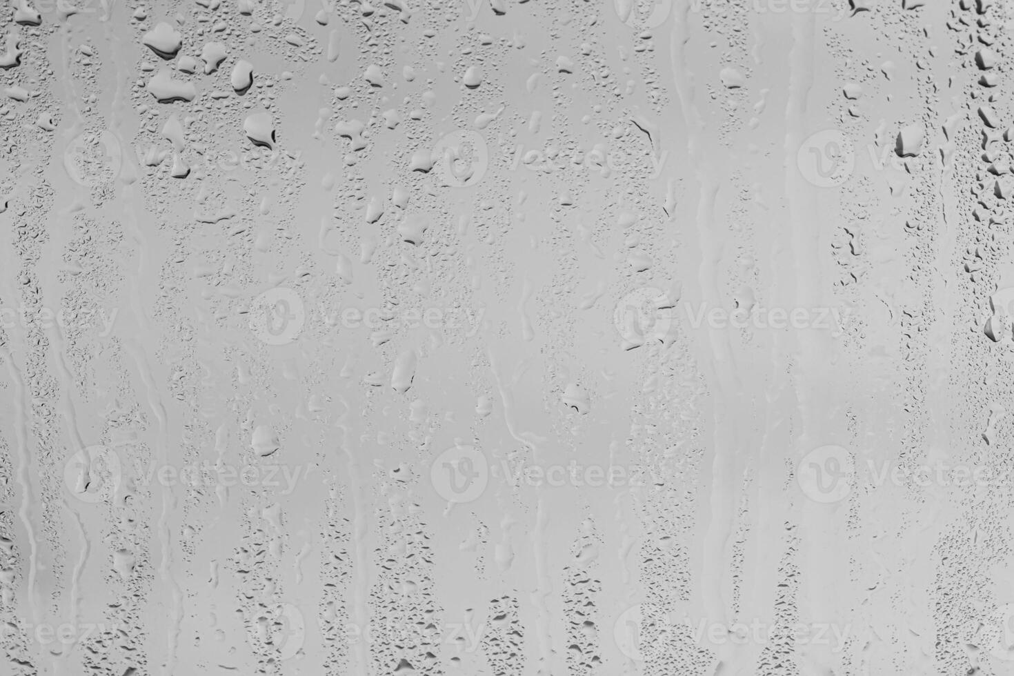 Rain drops on window glasses surface with gray sky background . Natural backdrop of raindrops. Overlay for design. The concept of bad rainy weather. photo