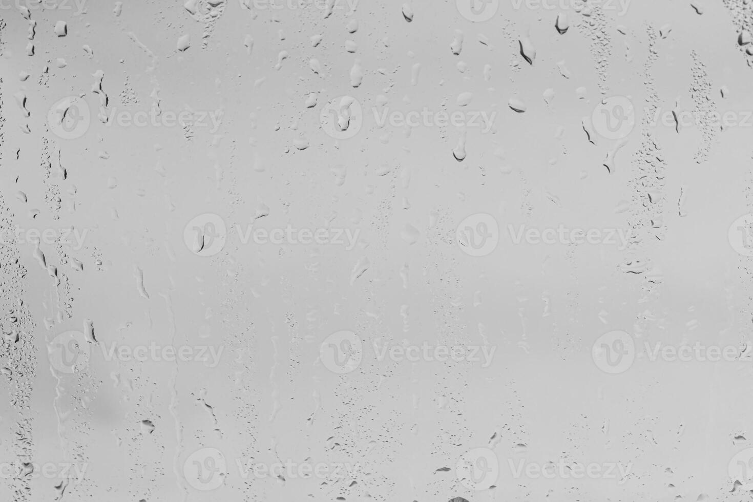 Rain drops on window glasses surface with gray sky background . Natural backdrop of raindrops. Overlay for design. The concept of bad rainy weather. photo
