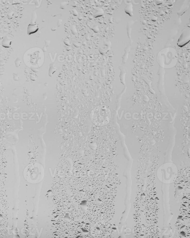 Rain drops on window glasses surface with gray sky background . Natural backdrop of raindrops. Overlay for design. The concept of bad rainy weather. photo