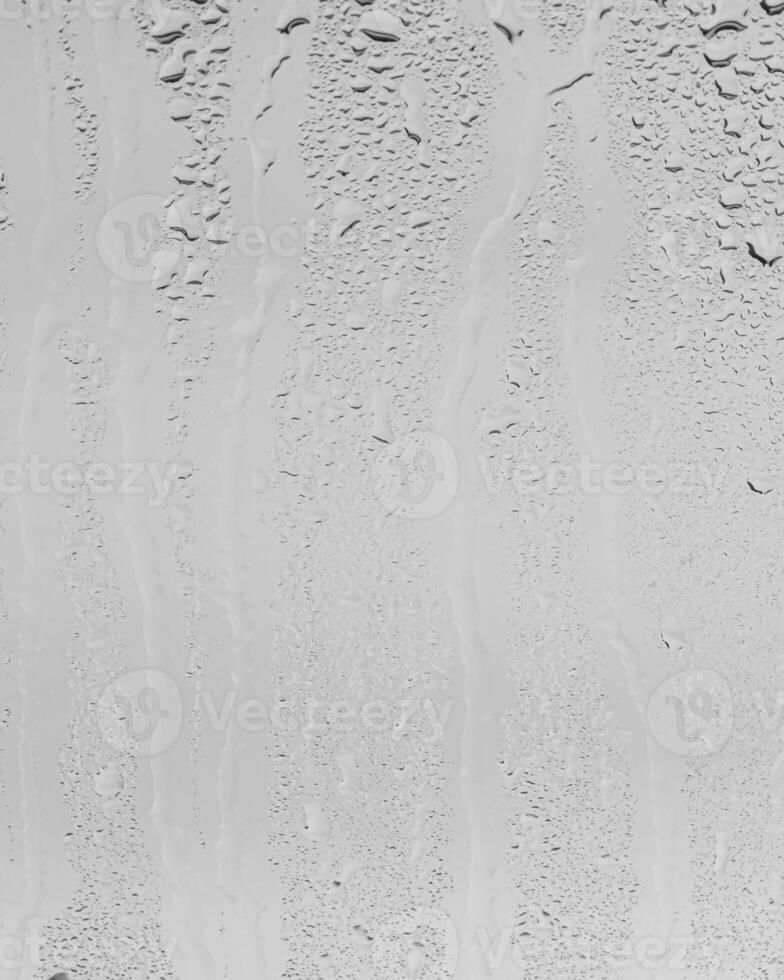 Rain drops on window glasses surface with gray sky background . Natural backdrop of raindrops. Overlay for design. The concept of bad rainy weather. photo