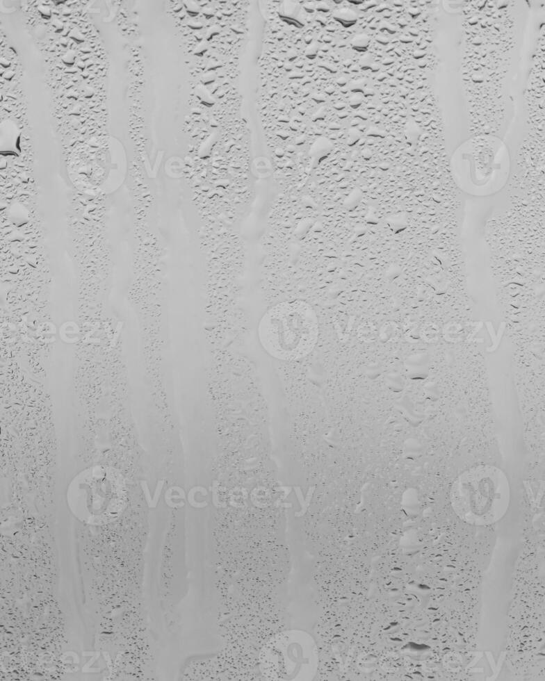 Rain drops on window glasses surface with gray sky background . Natural backdrop of raindrops. Overlay for design. The concept of bad rainy weather. photo