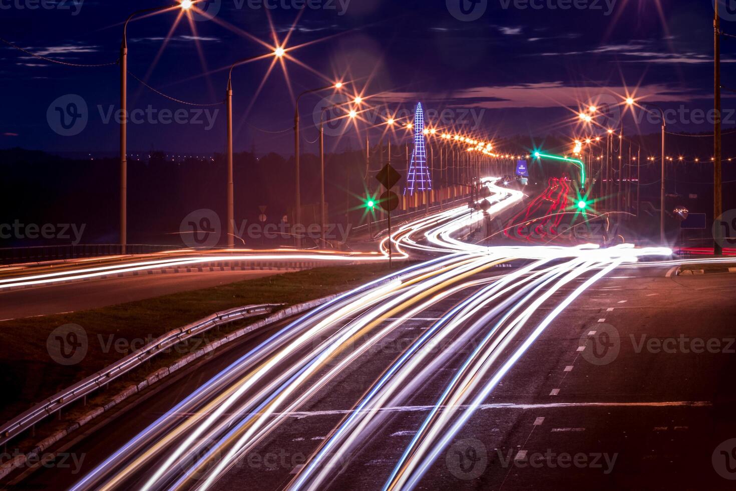 Traces of headlights from cars moving at night on the bridge, illuminated by lanterns. Abstract cityscape with highway at dusk. photo
