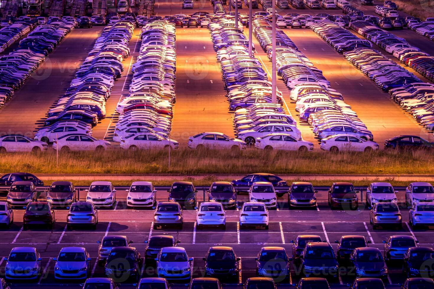Volkswagen, Russia, Kaluga - AUGUST 26, 2020 New cars parked at distribution center automobile factory at night with lights. Parking on the open air. photo