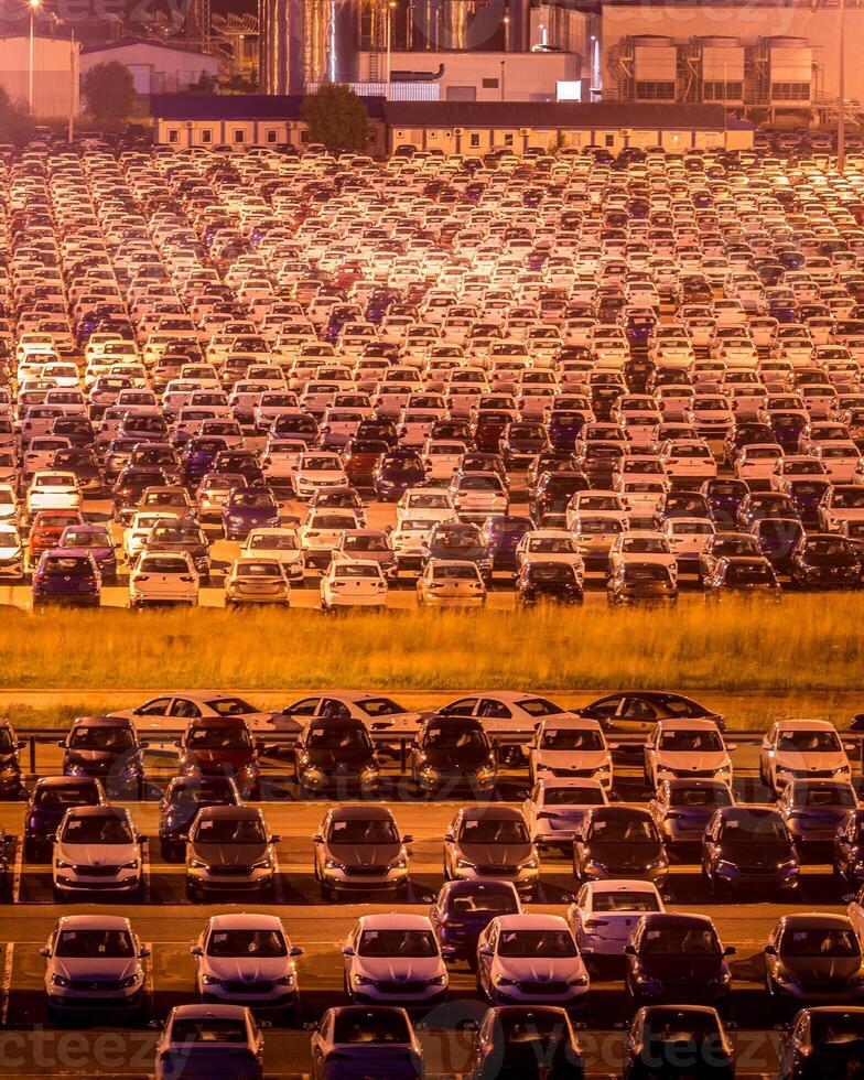 Volkswagen, Russia, Kaluga - AUGUST 26, 2020 New cars parked at distribution center automobile factory at night with lights. Parking on the open air. photo