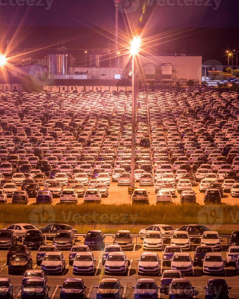 Volkswagen, Russia, Kaluga - AUGUST 26, 2020 New cars parked at distribution center automobile factory at night with lights. Parking on the open air. photo