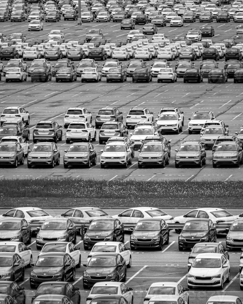 Volkswagen Group Rus, Russia, Kaluga - MAY 24, 2020 Rows of a new cars parked in a distribution center on a day in the spring, a car factory. Parking in the open air. Black and white photo. photo