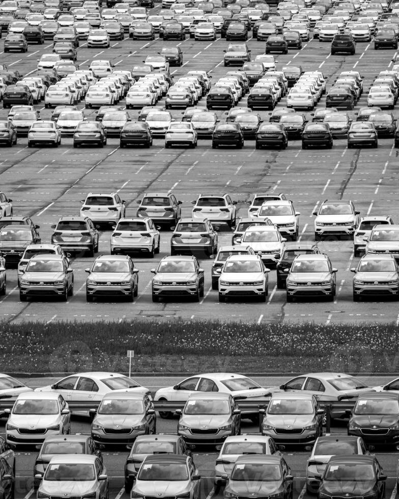 Volkswagen Group Rus, Russia, Kaluga - MAY 24, 2020 Rows of a new cars parked in a distribution center on a day in the spring, a car factory. Parking in the open air. Black and white photo. photo