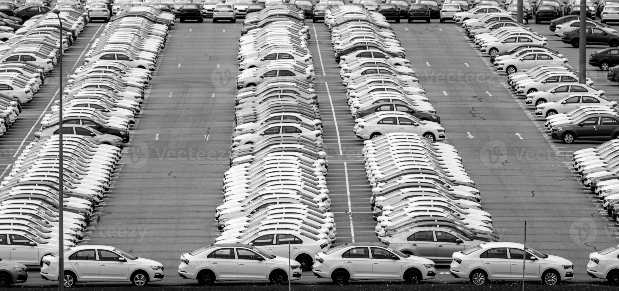 Volkswagen Group Rus, Russia, Kaluga - MAY 24, 2020 Rows of a new cars parked in a distribution center on a day in the spring, a car factory. Parking in the open air. Black and white photo. photo