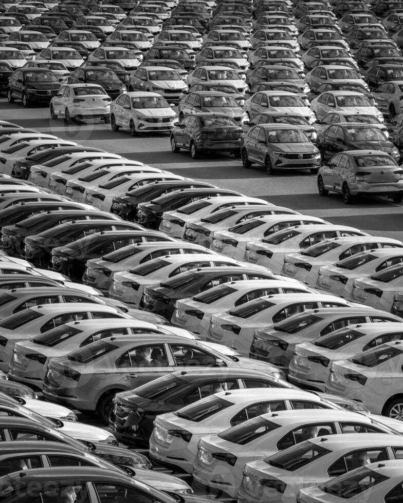 Volkswagen Group Rus, Russia, Kaluga - MAY 24, 2020 Rows of a new cars parked in a distribution center on a day in the spring, a car factory. Parking in the open air. Black and white photo. photo