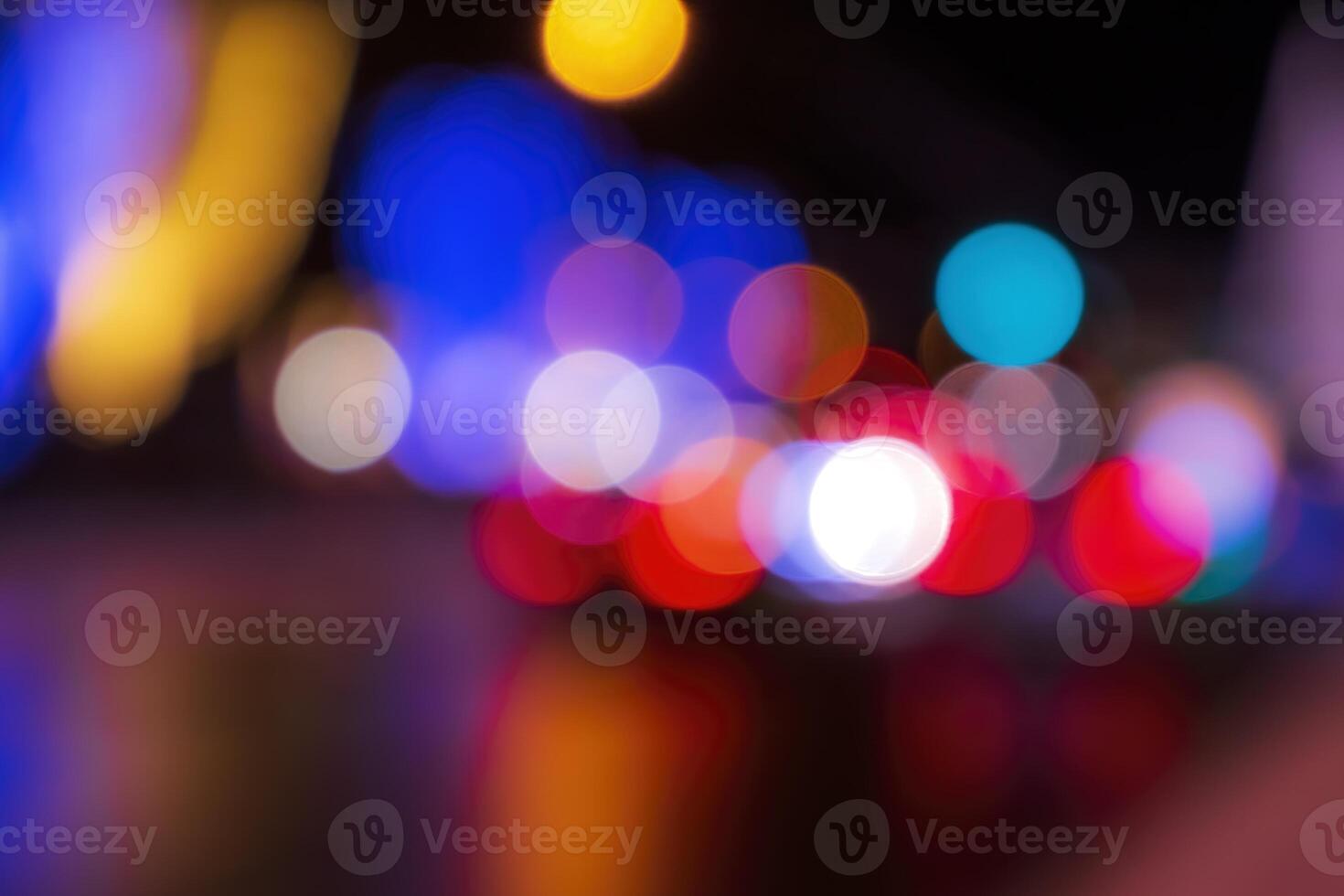 Blurred lights of headlights of cars and lanterns in the night city. Abstract bokeh. photo