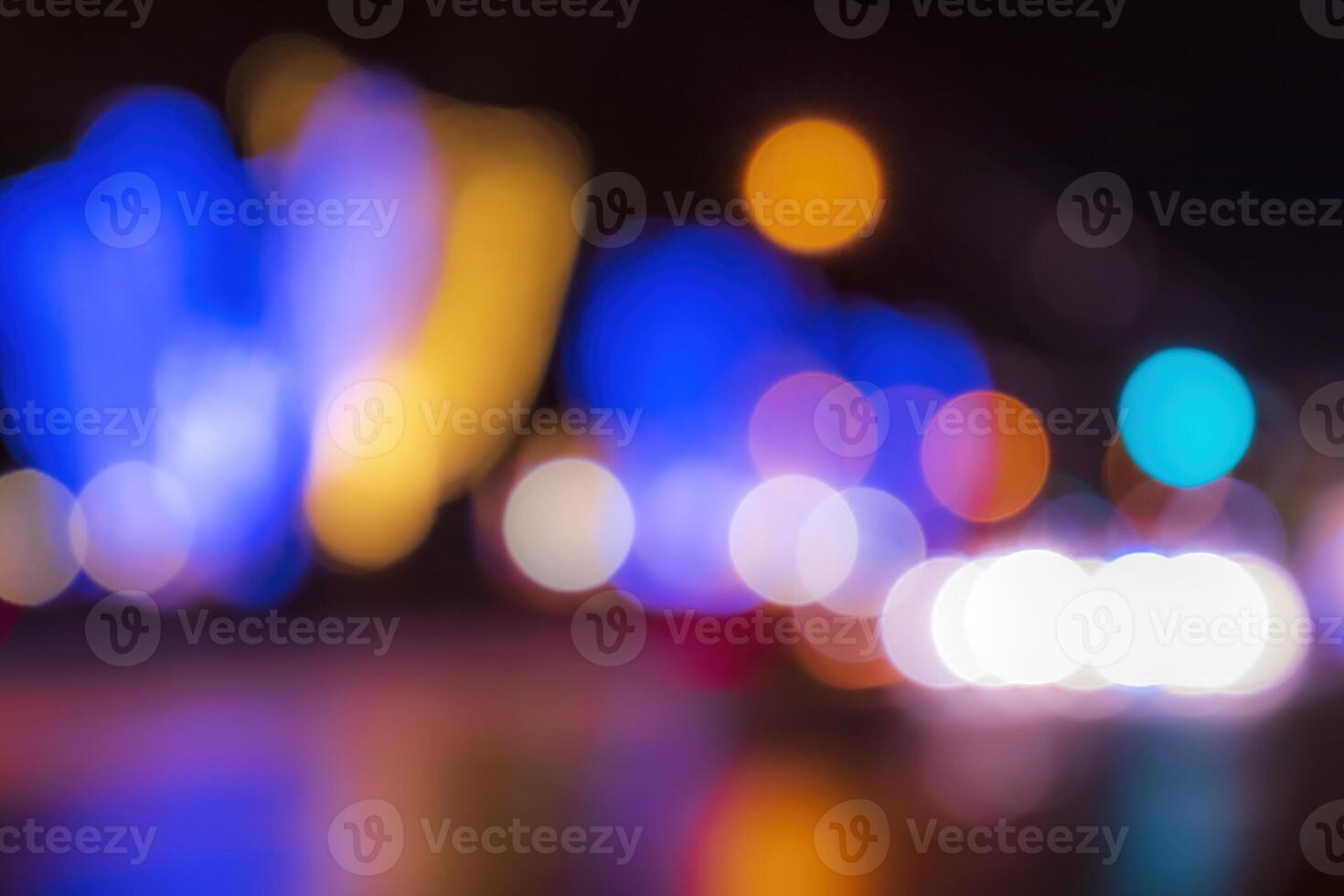 Blurred lights of headlights of cars and lanterns in the night city. Abstract bokeh. photo