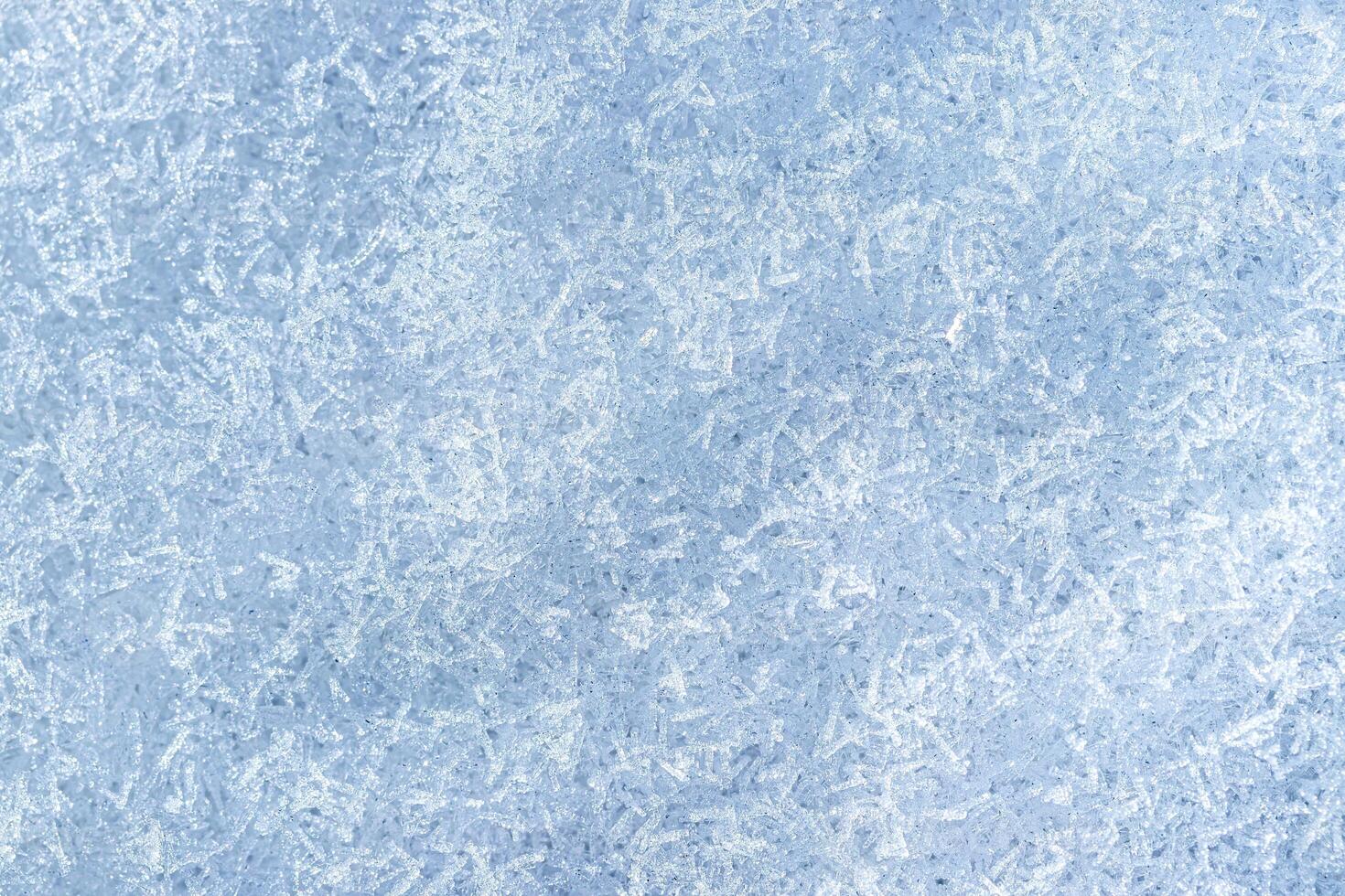Top view of snow crystals illuminated by sunlight. Winter background. photo