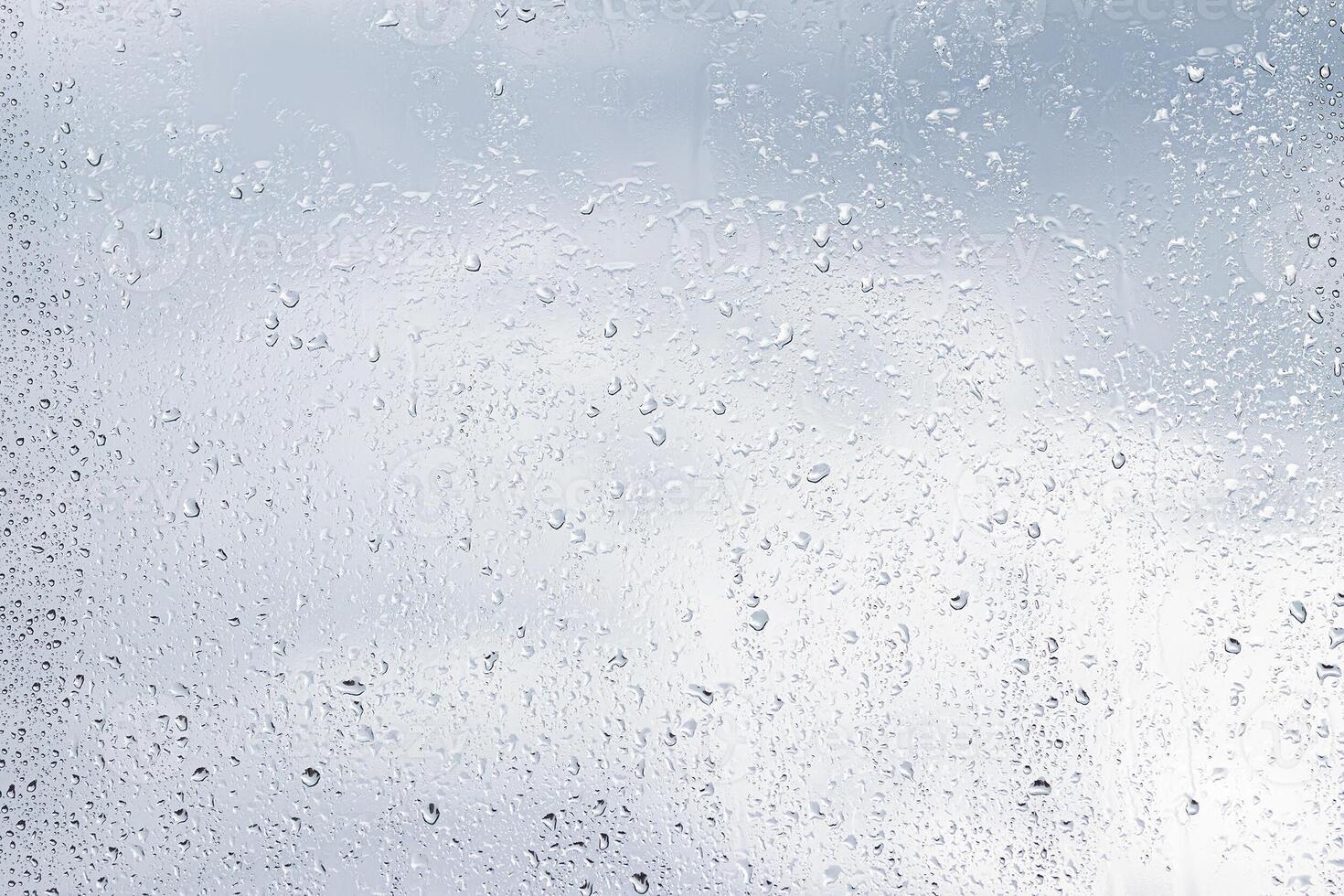 Rain drops on window glasses surface with cloudy background . Natural backdrop of raindrops. Abstract overlay for design. The concept of rainy weather. photo