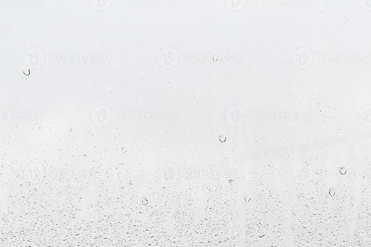 Rain drops on window glasses surface with gray sky background . Natural backdrop of raindrops. Abstract overlay for design. The concept of rainy weather. photo