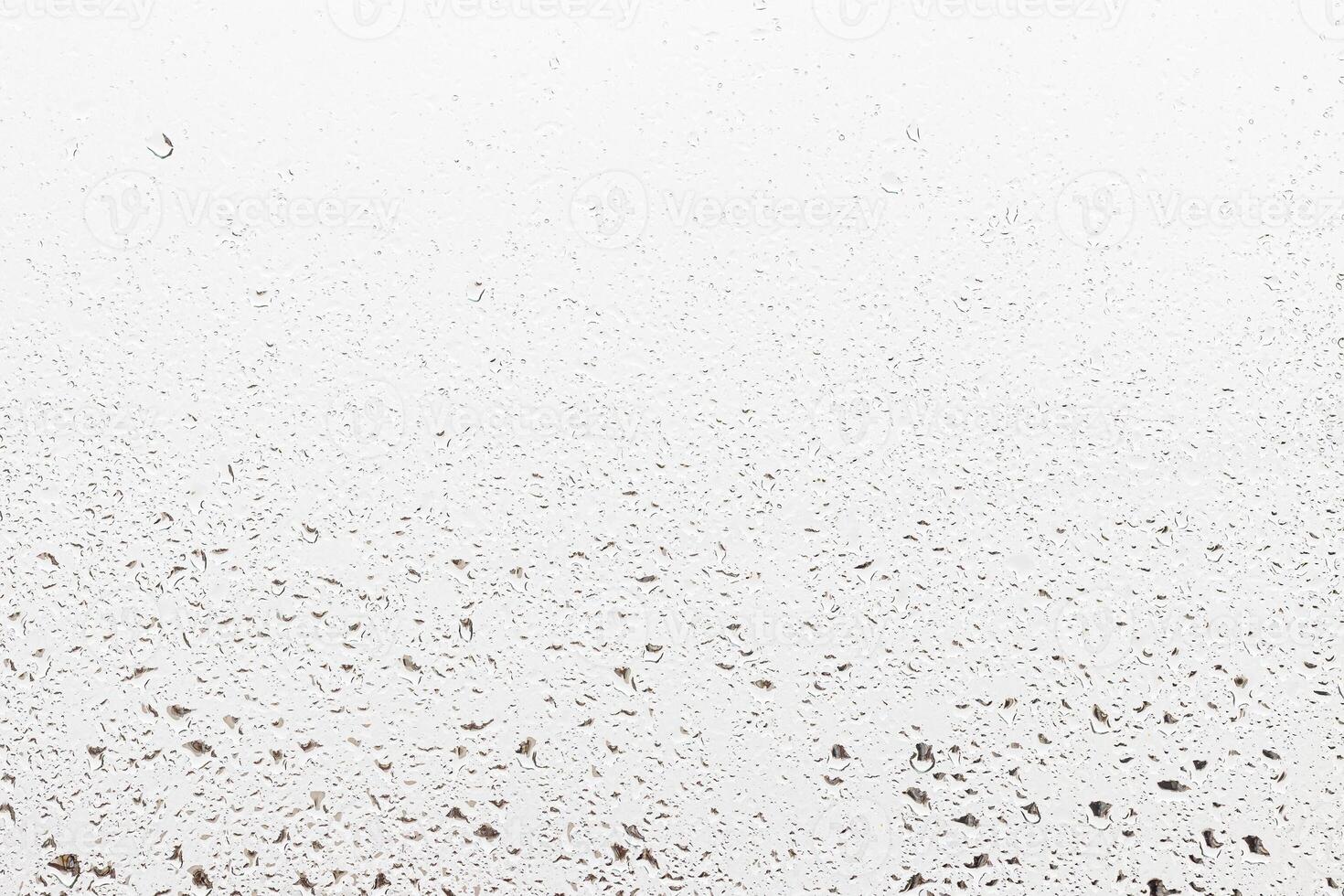 Rain drops on window glasses surface with gray sky background . Natural backdrop of raindrops. Abstract overlay for design. The concept of rainy weather. photo