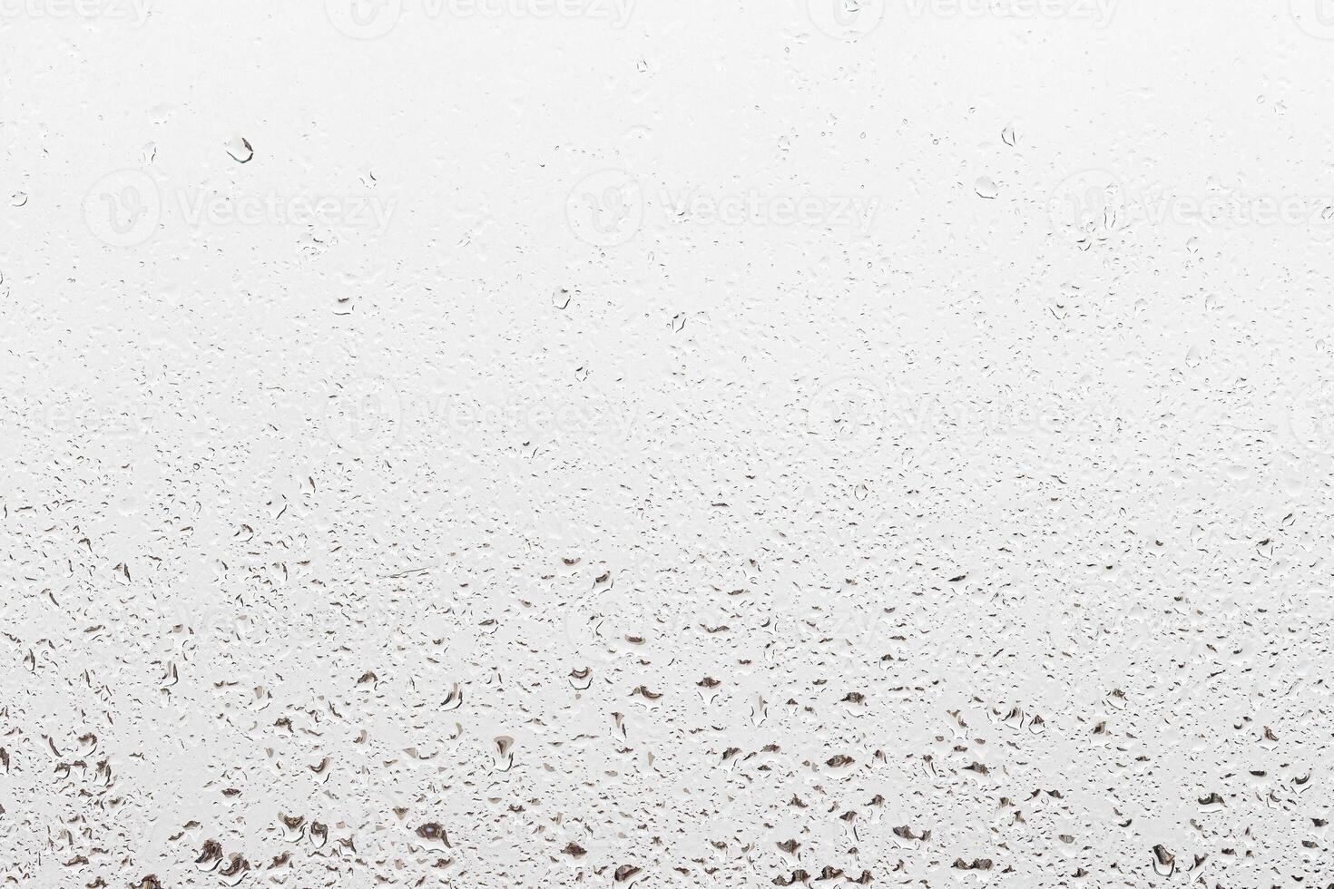 Rain drops on window glasses surface with gray sky background . Natural backdrop of raindrops. Abstract overlay for design. The concept of rainy weather. photo