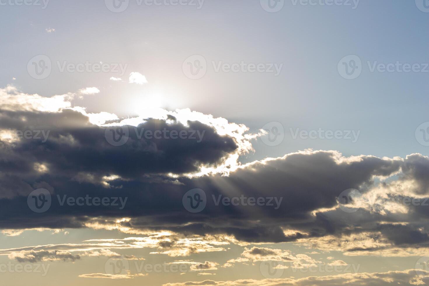 Sun rays breaking through cumulus clouds. The concept of divine light, a glimmer of hope or overcoming difficulties. Spiritual religious background. photo