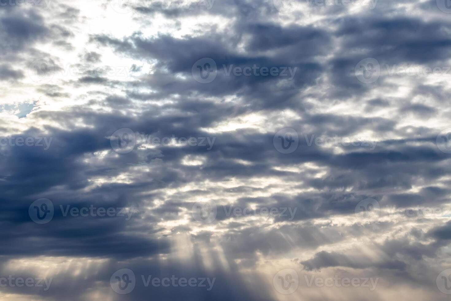 Sun rays breaking through cumulus clouds. The concept of divine light, a glimmer of hope or overcoming difficulties. Spiritual religious background. photo