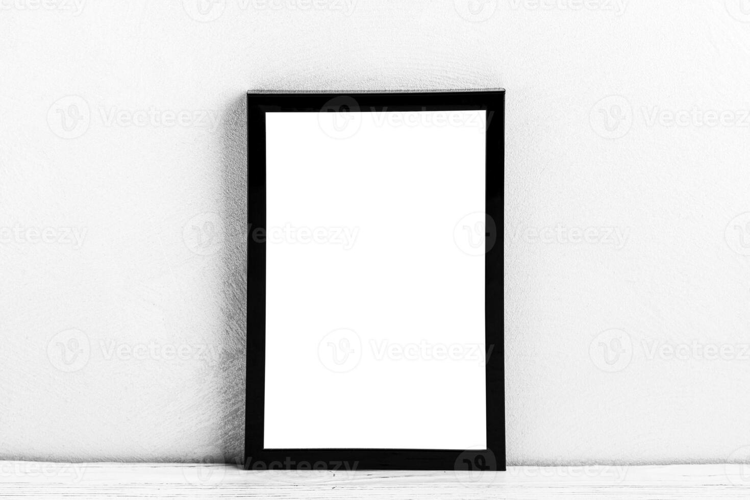 White wooden floor over concrete or decorative plaster wall and black photo frame with copy space for a text background. Mock up.
