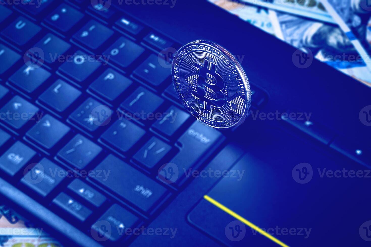 Dollar bills, black keyword and metal souvenir bitcoin. The concept of electronic money, online trading, mining and commerce. Cryptocurrency and cash. photo