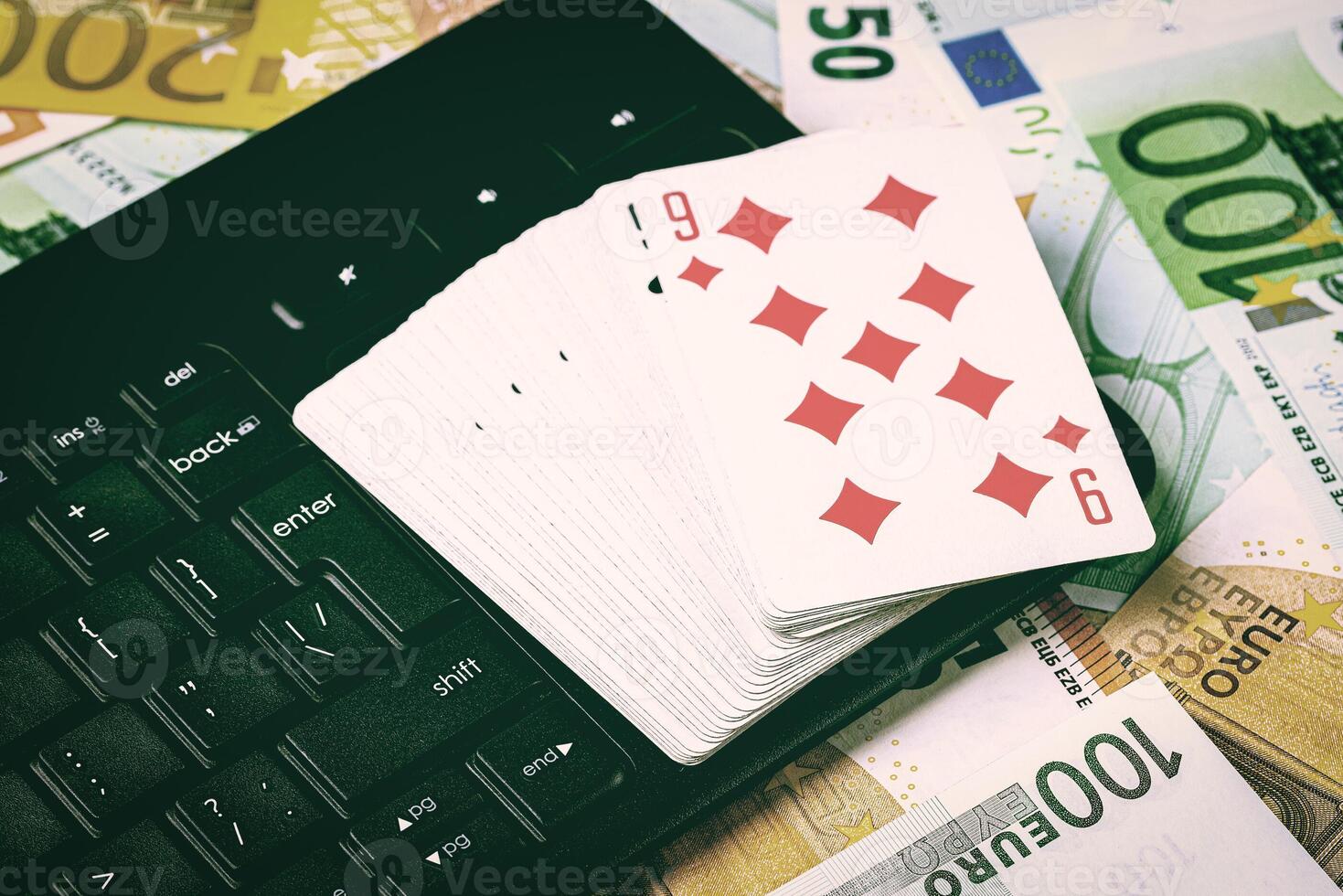 Euro bills, a deck of playing cards and a black keyboard. Concept of card games, casino or poker online. Online gambling. photo