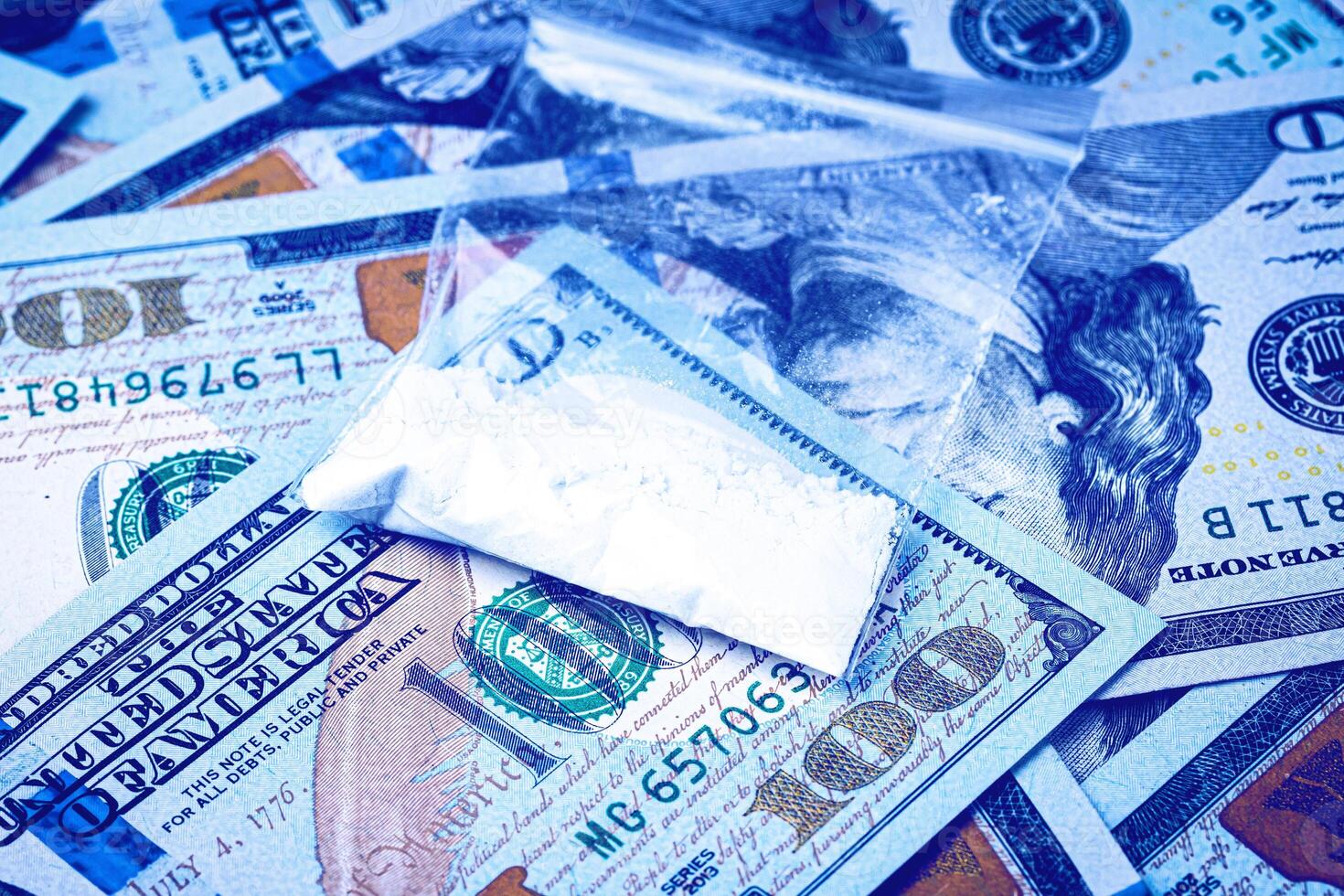 A bag with white narcotic powder like heroin or cocaine on the background of one hundred dollar bills. The concept of the use and sale of drugs. photo