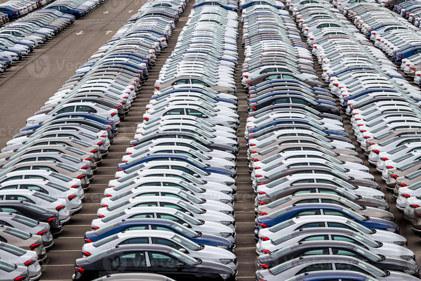 Rows of a new cars parked in a distribution center of a car factory. Top view to the parking in the open air. photo