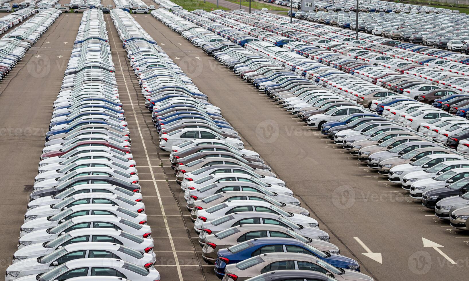 Rows of a new cars parked in a distribution center of a car factory. Top view to the parking in the open air. photo
