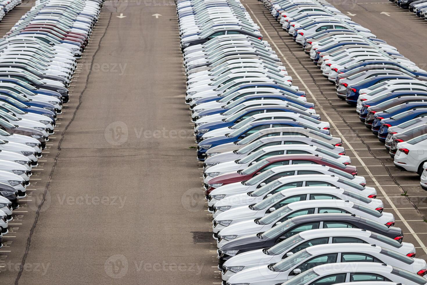 Rows of a new cars parked in a distribution center of a car factory. Top view to the parking in the open air. photo