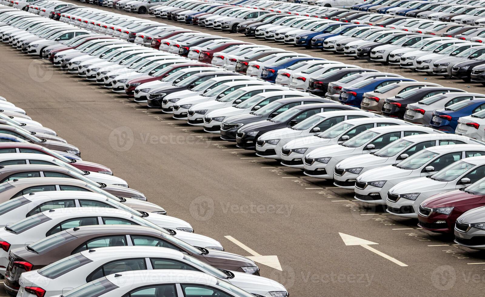Rows of a new cars parked in a distribution center of a car factory. Top view to the parking in the open air. photo