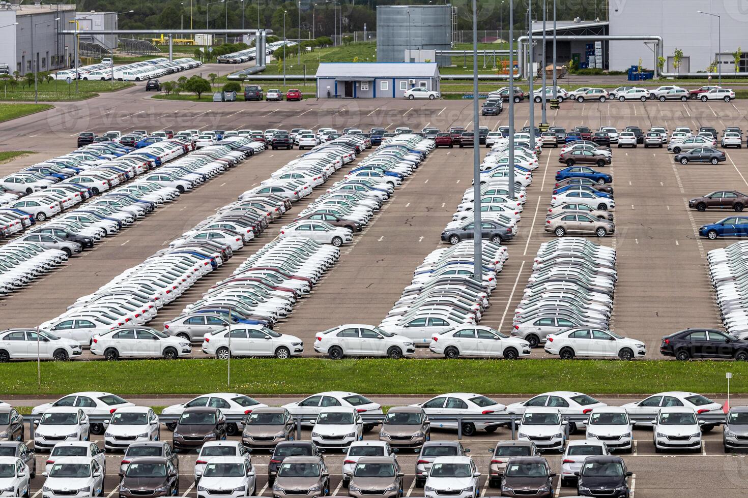 Volkswagen Group Rus, Russia, Kaluga - MAY 24, 2020 Rows of a new cars parked in a distribution center on a cloudy day in the spring, a car factory. Parking in the open air. photo