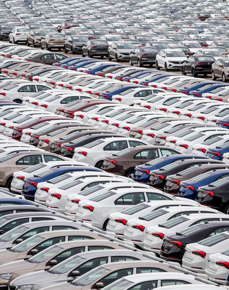 Volkswagen Group Rus, Russia, Kaluga - MAY 24, 2020 Rows of a new cars parked in a distribution center on a cloudy day in the spring, a car factory. Parking in the open air. photo