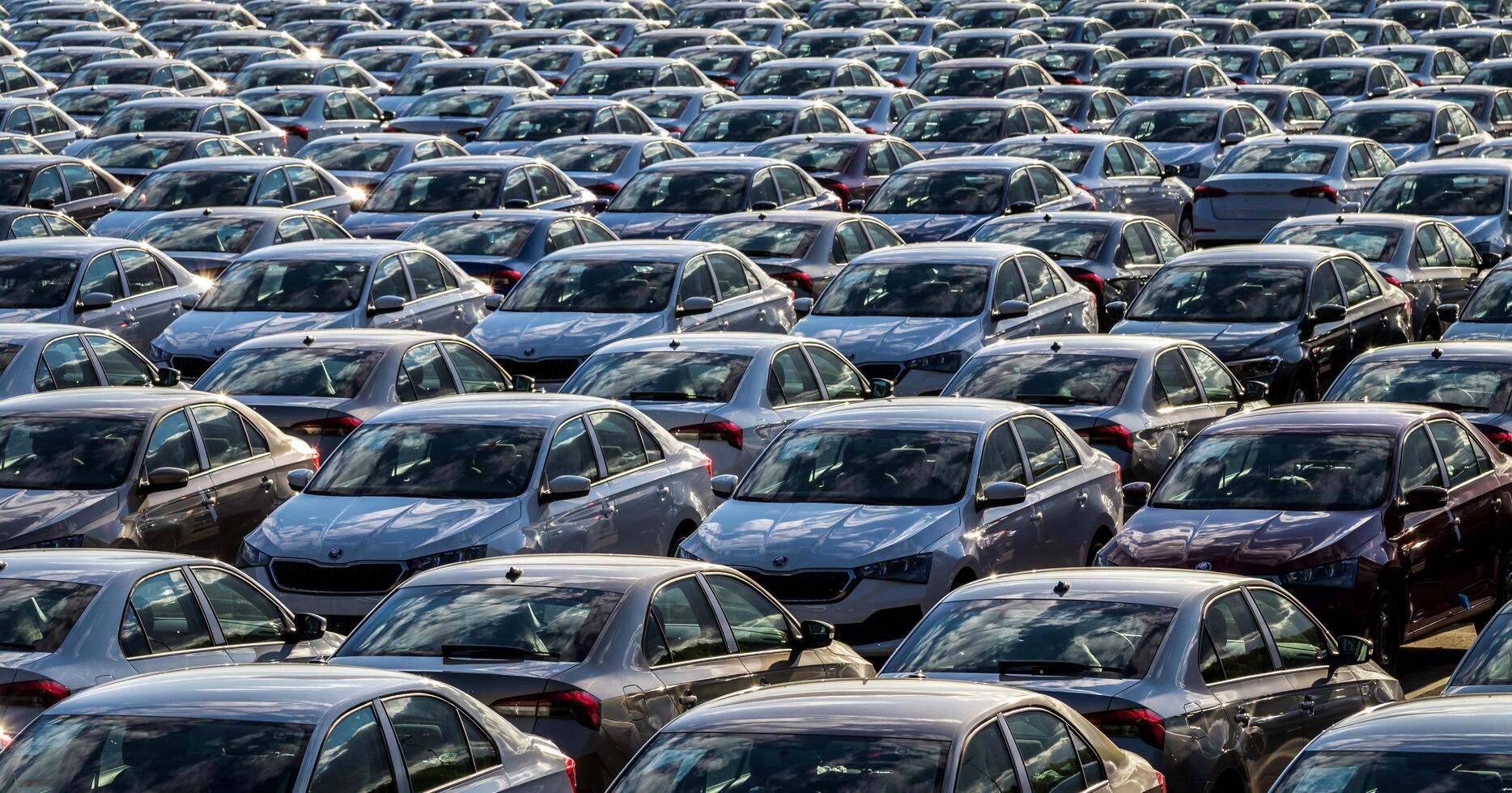 Volkswagen Group Rus, Russia, Kaluga - MAY 25, 2020 Rows of a new cars parked in a distribution center on a sunny day in the spring. Top view to a parking in the open air. photo