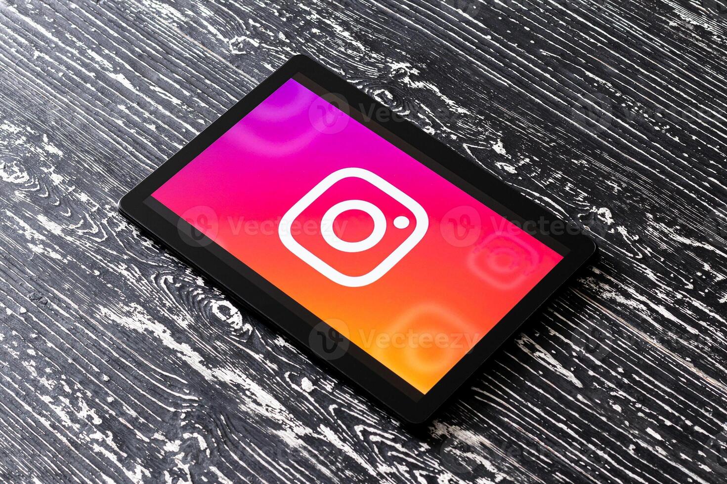 Tablet computer on a white wooden table with a social network instagram logo. photo