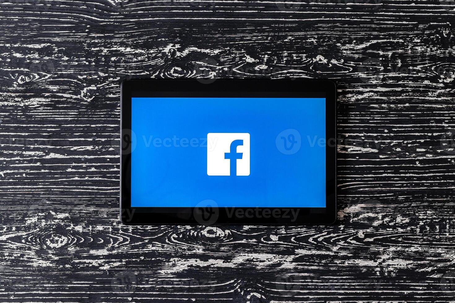 tableta computadora en un negro de madera mesa con un social red Facebook logo. foto