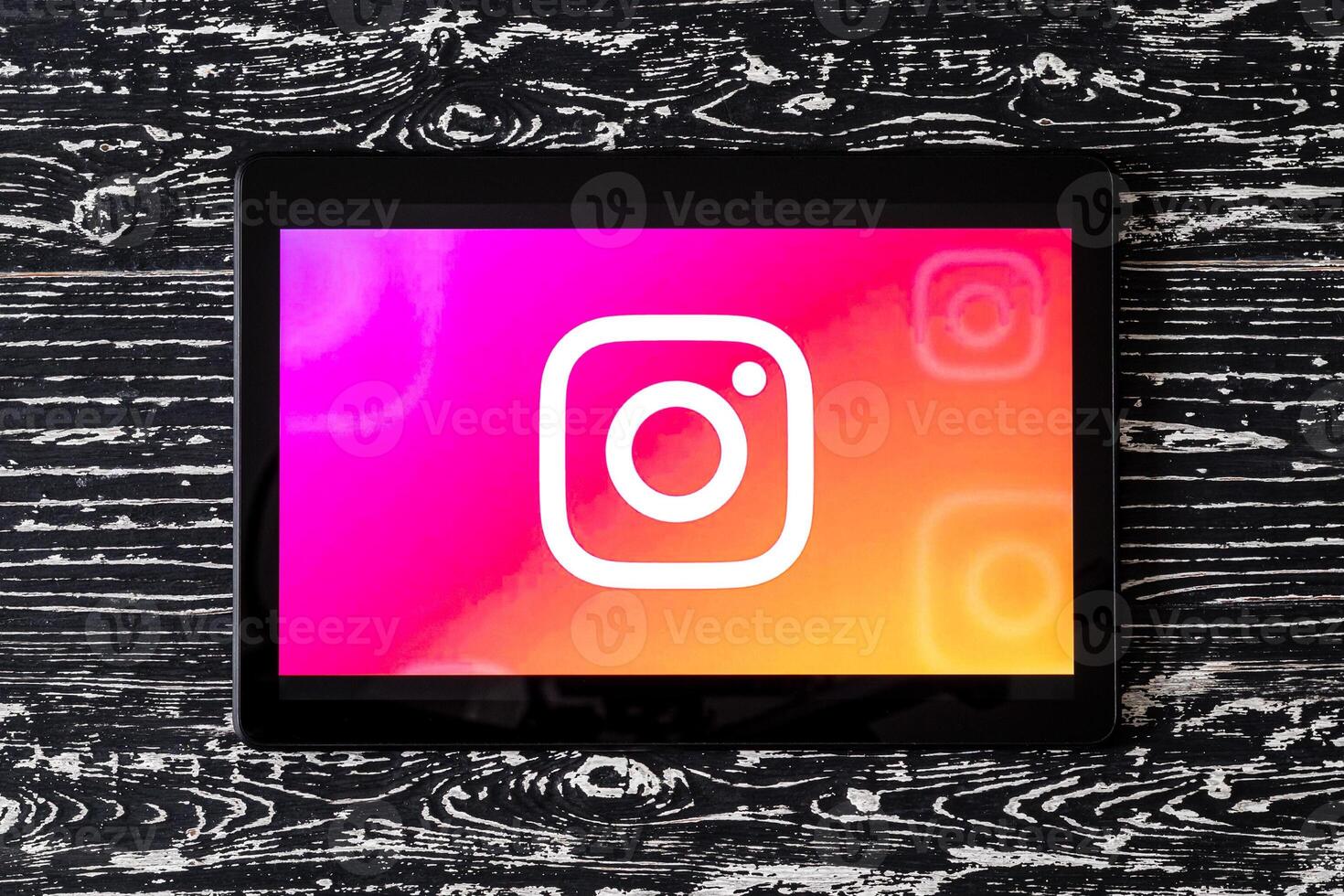 Tablet computer on a white wooden table with a social network instagram logo. photo
