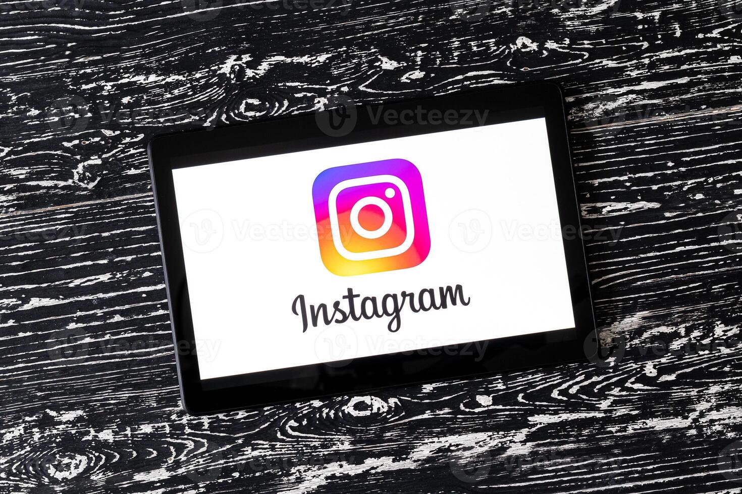 Tablet computer on a white wooden table with a social network instagram logo. photo