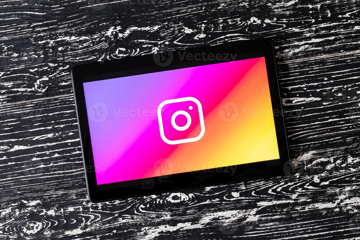 Tablet computer on a white wooden table with a social network instagram logo. photo